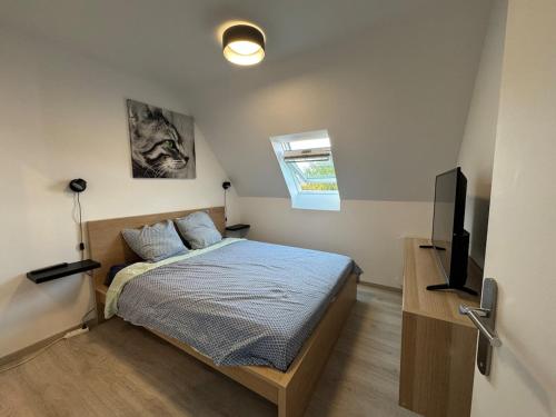 Beachfront apartment with pool في دوفيل: غرفة نوم بها سرير وتلفزيون بشاشة مسطحة