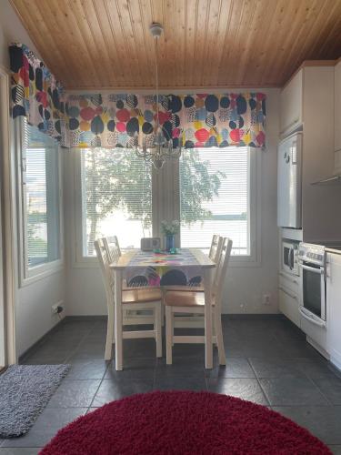 a dining room with a table and chairs in a kitchen at Pikkuhelmi-huvila in Eurajoki