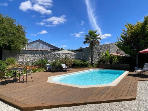- une piscine sur une terrasse en bois à côté d'une maison dans l'établissement Le clos des grandes rivières, à Sainte-Soulle