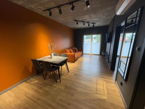 a living room with a table and a couch at Apartament Baltic 13 Mielno in Mielno
