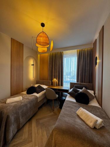 a hotel room with two beds and a desk at Family & Business Sauna Apartments Baltic Horizon No 1 PREMIUM SPA - 3 Bedroom with Private Sauna, Jacuzzi, Rooftop Gym & Panoramic Terrace, Balcony, Underground Garage in Gdańsk