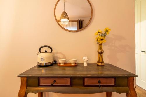 a table with a tea kettle and a vase with flowers at Mediha Hanım Konağı Alaçatı in Cesme