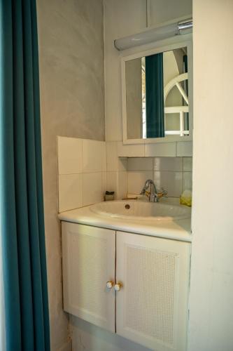 une salle de bain avec un lavabo et un miroir dans l'établissement La Parenthèse Campagnarde, à Richarville