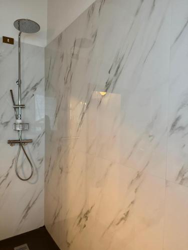a shower in a bathroom with white marble walls at Tenuta Massabò in San Casciano in Val di Pesa