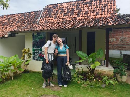 a man and a woman standing in front of a house at Tiara Homestay Banyuwangi in Banyuwangi
