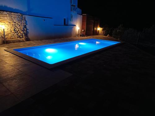 a swimming pool lit up at night with lights at Villa TOP HILL - Private Pool & Jacuzzi in Makarska