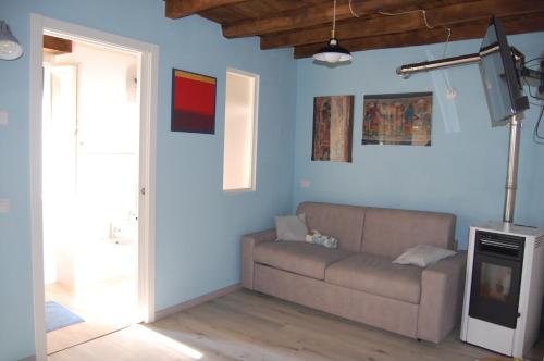 a living room with a couch and a tv at PRIMA DEL CIELO - appartamento LAGO in Esino Lario