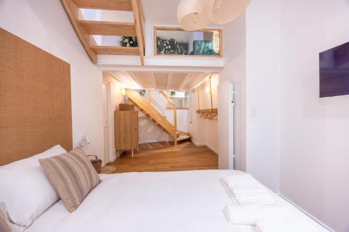 une chambre avec un lit blanc et un escalier dans l'établissement La P'tite Barque des Remparts Plage, à Saint-Malo