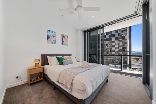 Un dormitorio con una cama y una ventana grande. en New Private Apt on Star Casino Brisbane, en Brisbane
