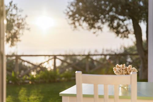 a white chair sitting at a table with a vase of flowers at Casa Clementina Marciano in Massa Lubrense