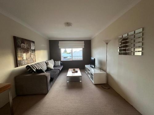 a living room with a couch and a tv at Makkadesh Homes in Bunbury