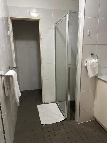 a bathroom with a shower with a glass door at Makkadesh Homes in Bunbury