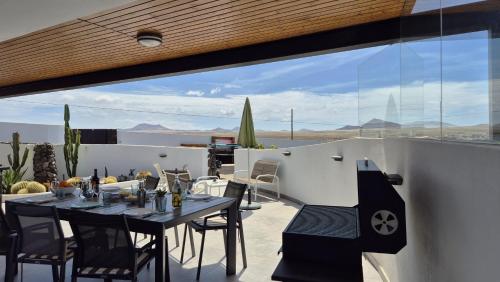 a patio with a table and chairs on a balcony at La Belle Vie in Famara