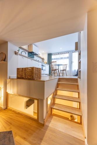 une cuisine avec des escaliers menant à un salon dans l'établissement La P'tite Barque des Remparts Plage, à Saint-Malo