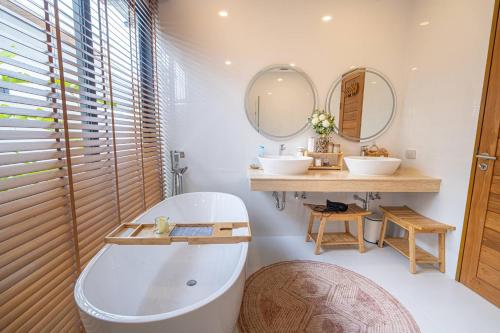 a bathroom with two sinks and a tub and two mirrors at Villa Natali - Lamai in Amphoe Koh Samui