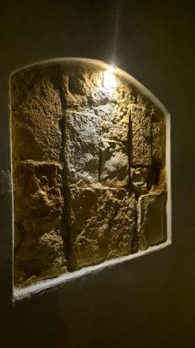 a stone wall with the light shining on it at Paglia d'Oro Luxury Flat in Lotzorai
