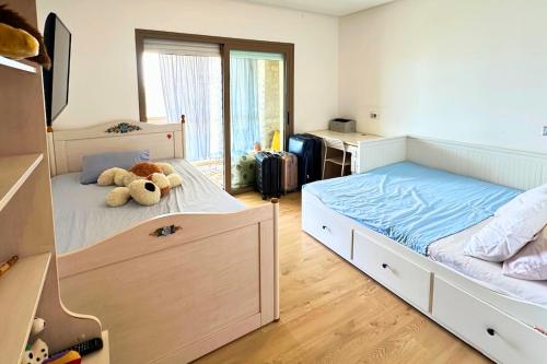 a bedroom with a bed with a teddy bear on it at Ocean View Prestigia Residence in Sidi Bouqnadel
