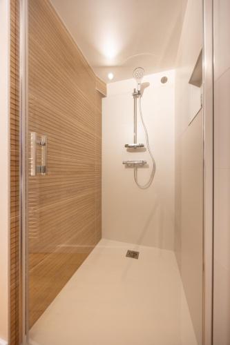 une douche avec une porte vitrée dans une salle de bain dans l'établissement La P'tite Barque des Remparts Plage, à Saint-Malo