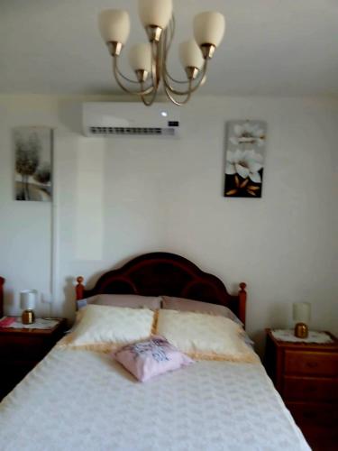 a bedroom with a bed and a chandelier at Casa Jardim in Ponta do Pargo