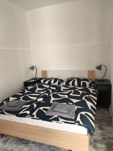 a bed with a black and white comforter and two lamps at Zusy in Orebić