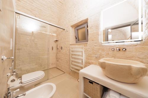 a bathroom with a sink and a toilet and a shower at AGLEA trulli e suite in Alberobello