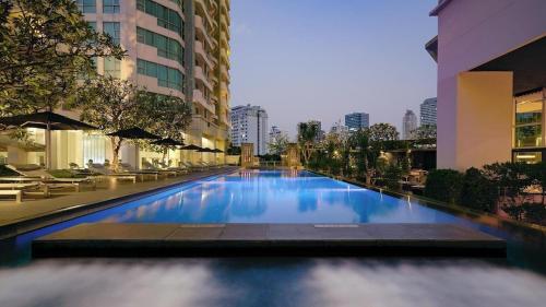 a large swimming pool in the middle of a building at Sathorn prime Panorama City View rooftop bar in Bangkok