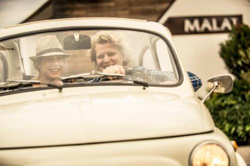 a man and a woman sitting in a car at MALAT Weingut und Hotel in Furth