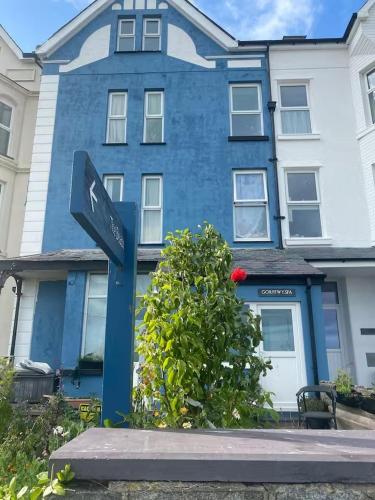 a blue house with a street sign in front of it at Explorer Room Ensuite Mountain View 3rd floor in Pwllheli