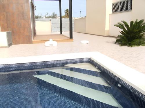 a swimming pool in the middle of a house at Adosado cerca del mar con piscina privada in Vinaròs