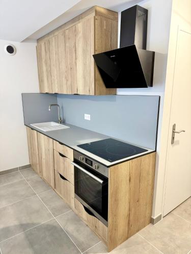 a kitchen with a sink and a stove at Duplex 4 personnes avec jardin in Brantôme