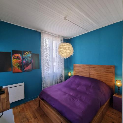 a bedroom with a purple bed and a blue wall at Maison charmante, années 30 avec extérieur à l'Ile Verte in Grenoble