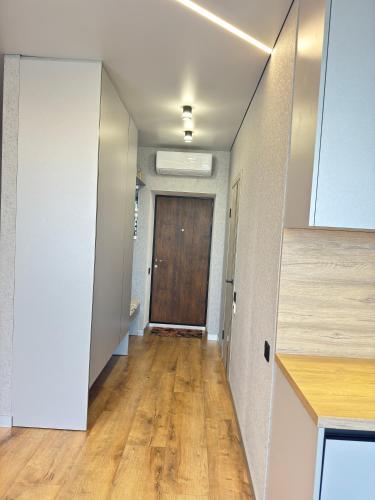 an empty hallway with a door and a wooden floor at Квартира Фонтанка, ТРЦ Рів'єра, пляж Яхта in Fontanka