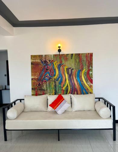 a couch in a room with a painting on the wall at The Beka - Diani Beach in Diani Beach