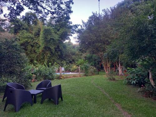 two chairs and a table in the grass at Casa de campo el lapacho in Colonia Mbopicuá