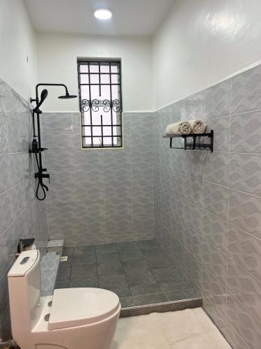 a bathroom with a toilet and a shower at The Beka - Diani Beach in Diani Beach