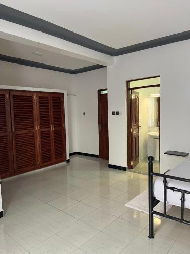 a room with a bed and a room with a door at The Beka - Diani Beach in Diani Beach