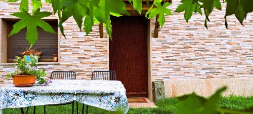 a table with a potted plant on it in front of a building at Lar do solpor in Allariz