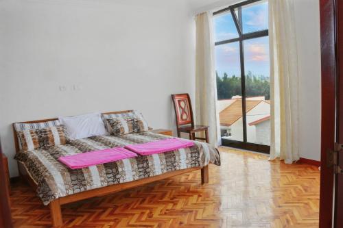 a bedroom with a bed and a large window at Large Villa with Driver Included in Addis Ababa