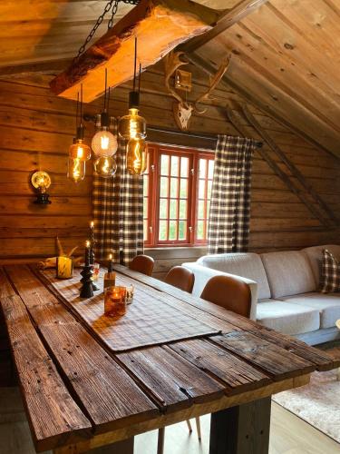 a wooden table in a living room with a couch at Raundalen in Løyte