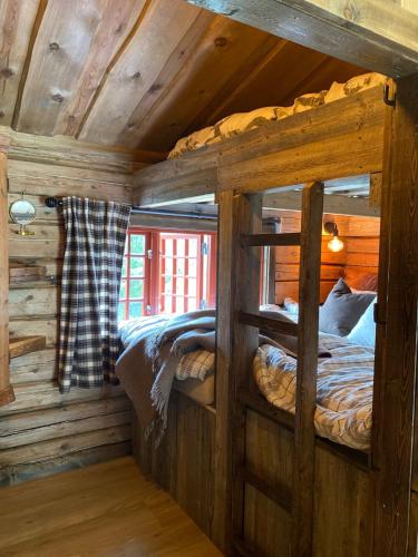 a bedroom with two bunk beds in a log cabin at Raundalen in Løyte