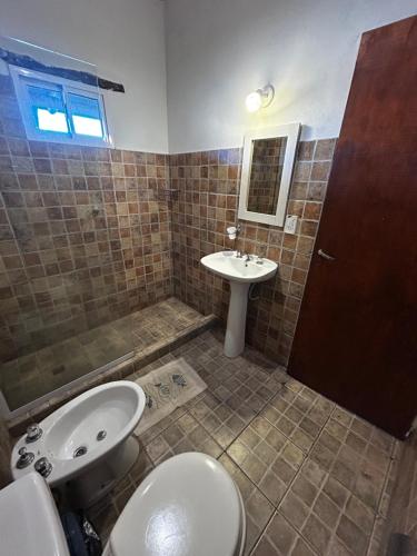 a bathroom with a sink and a toilet at cabañas Villa de las rosas in Villa de Las Rosas