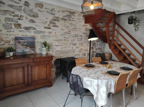 a dining room with a table and a staircase at NOUVEAU YS EO, La maison sur le port de Tréboul in Douarnenez