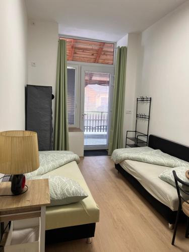 a room with two beds and a table and a window at UbytkoMácháč in Staré Splavy