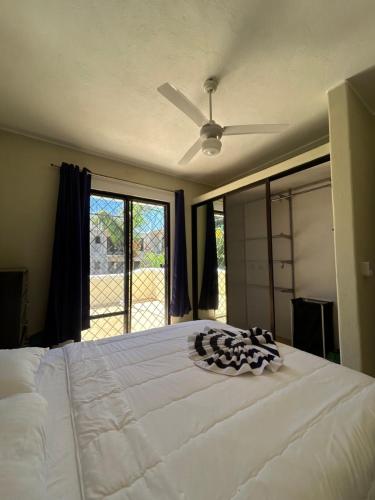 a bedroom with a large white bed with a ceiling fan at CASA Angelo in Sosúa