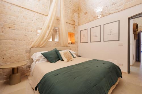a bedroom with a large bed in a brick wall at AGLEA trulli e suite in Alberobello