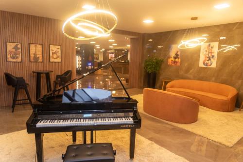 a piano in a living room with a couch at eSuites Sorocaba in Sorocaba