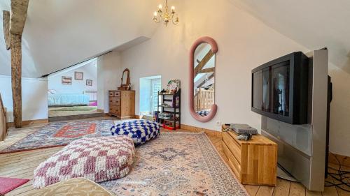 a living room with a flat screen tv and a couch at La Maison de Cécile in Cahan