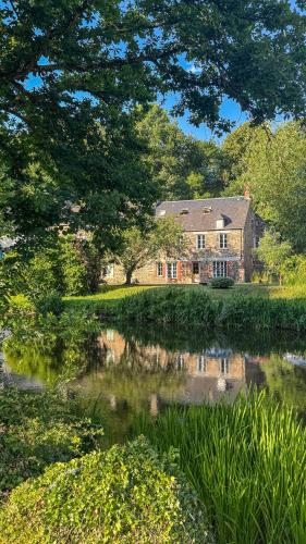 a large house with a pond in front of it at La Maison de Cécile in Cahan
