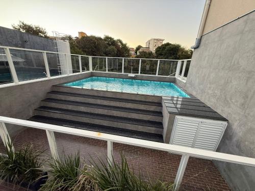 a swimming pool on the side of a building at eSuites Sorocaba in Sorocaba