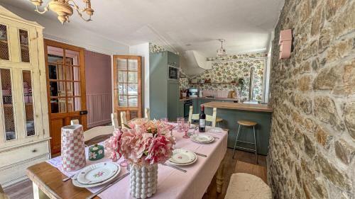 a kitchen with a table with a vase of flowers on it at La Maison de Cécile in Cahan